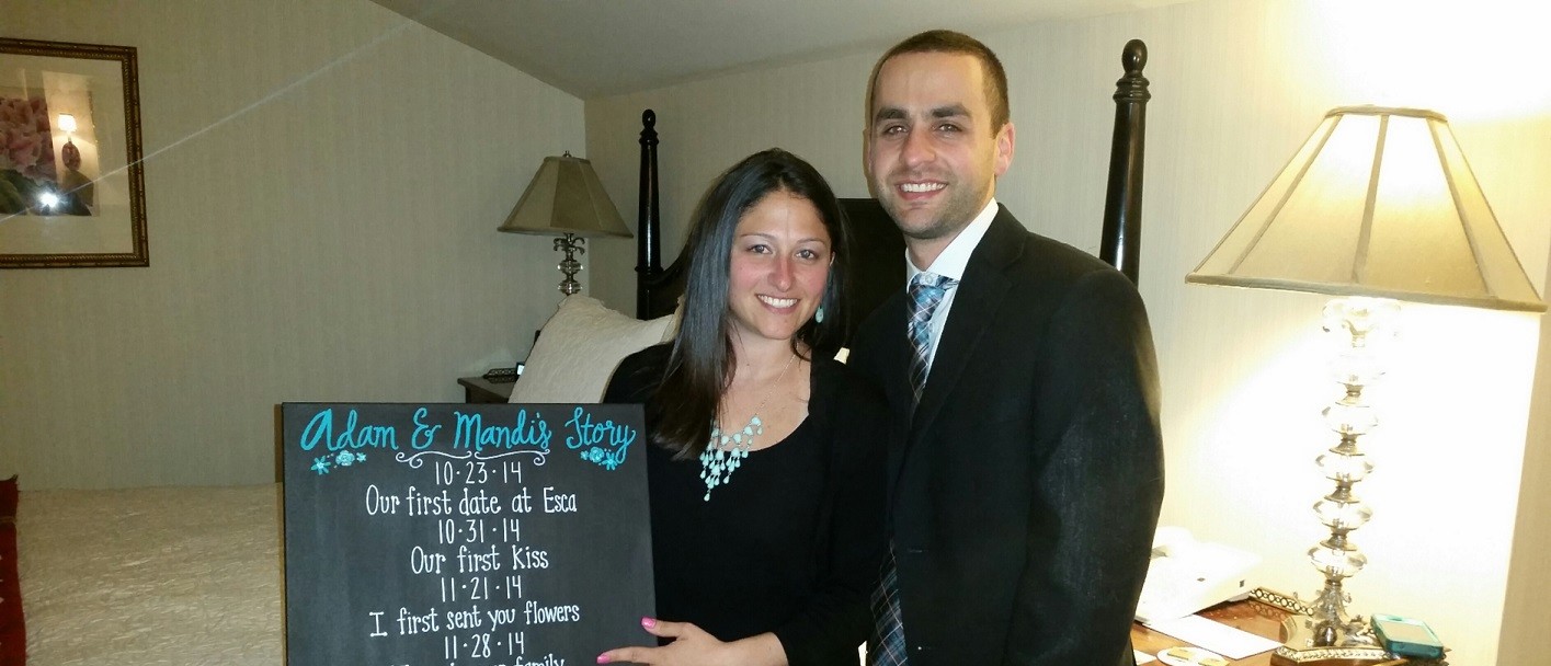 Mandi and Adam pose with a timeline of their relationship.