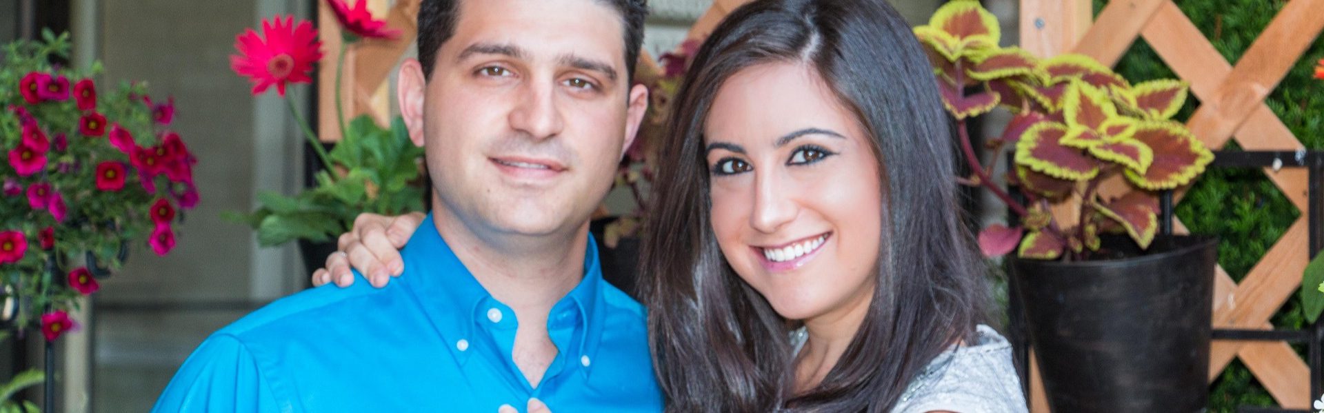 Amy and Jason dressed up and posing in a garden.